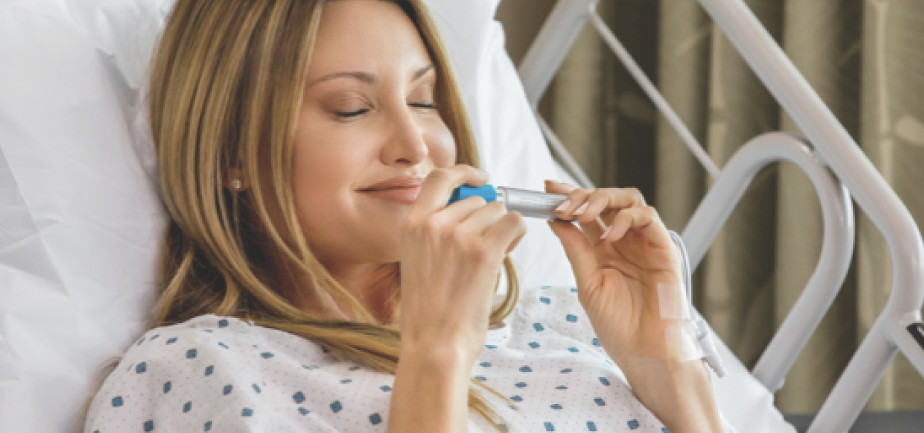 woman in hospital bed using a personal essential oil inhaler